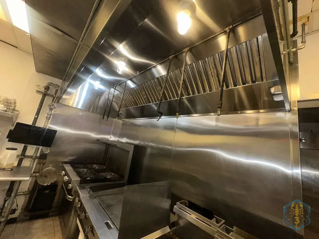 The cook line and stainless hood left clean at the end of an overnight service.